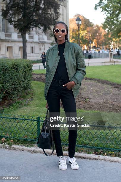 Model Leila Nda wears Adidas trainers, a Classic Urban jacket, Levi jeans, Derek Lam sunglasses and Givency bag on day 3 during Paris Fashion Week...