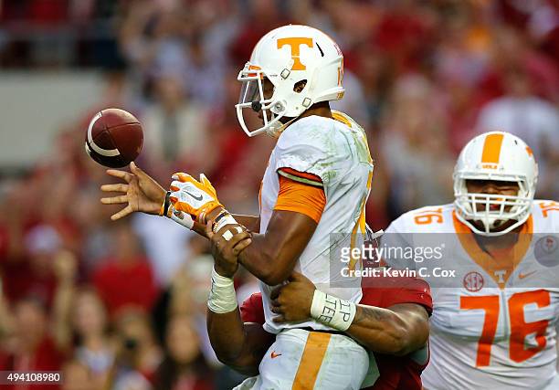 Joshua Dobbs of the Tennessee Volunteers turns the ball over as he fumbles off a tackle by Ryan Anderson of the Alabama Crimson Tide in the final...