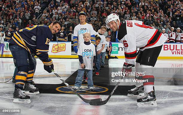 Carly's Club member Matthew Eggers drops the ceremonial puck between Brian Gionta of the Buffalo Sabres and Andy Greene of New Jersey Devils on...