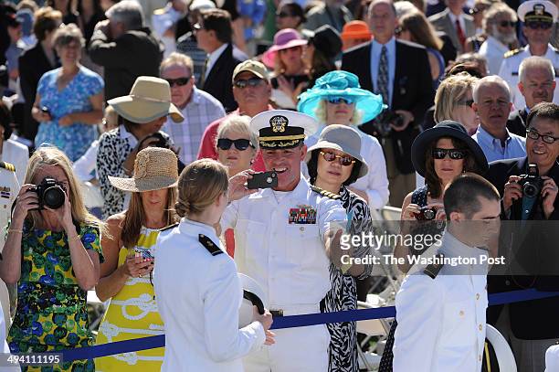 Friends and family take photos at the beginning of the United States Naval Academy graduation and commissioning ceremony at Navy-Marine Corps...
