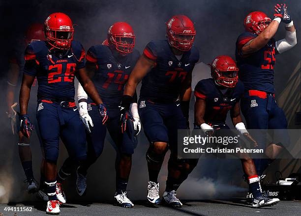 Nick Wilson, Paul Magloire Jr. #14, Lene Maiava, DaVonte' Neal and Jeff Worthy of the Arizona Wildcats take the field during introductions to the...