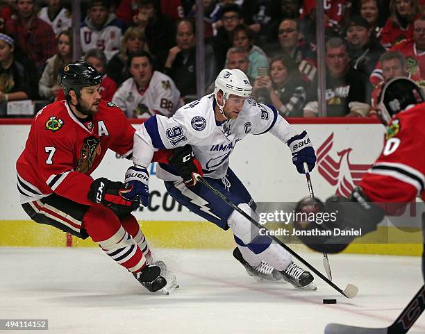 Steven Stamkos of the Tampa Bay Lightning is pressured by Brent Seabrook of the Chicago Blackhawks as he skates toward Corey Crawford at the United...