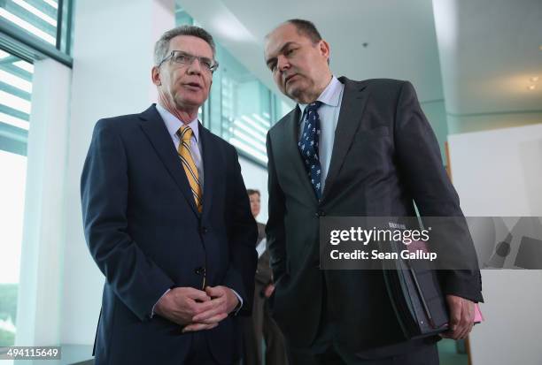 German Interior Minister Thomas de Maiziere and State Secretary Christian Schmidt chat upon their arrival at the weekly German government cabinet...