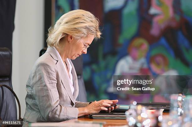 German Defense Minister Ursula von der Leyen reads from a smartphone upon her arrival at the weekly German government cabinet meeting on May 28, 2014...