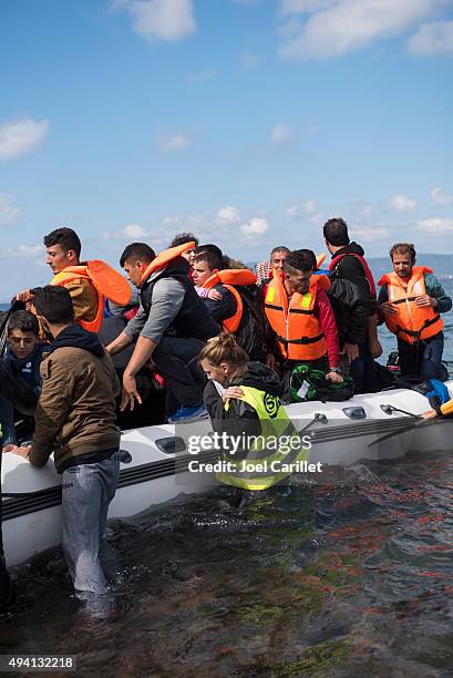 volunteer helping migrants arriving on lesbos - child trafficking stock pictures, royalty-free photos & images