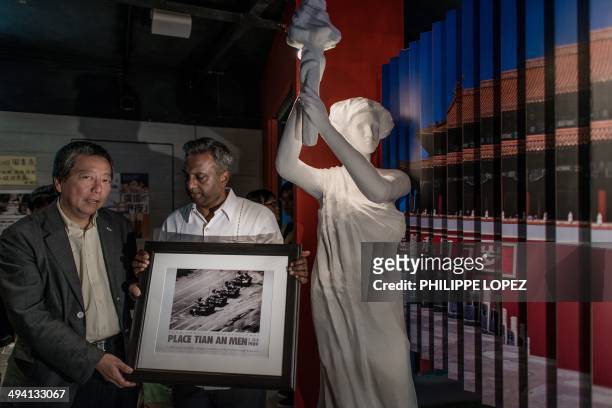Secretary General at Amnesty International Salil Shetty offers a reproduction of Jeff Widener's Tank Man photo to Lee Cheuk-yan, Hong Kong lawmaker...