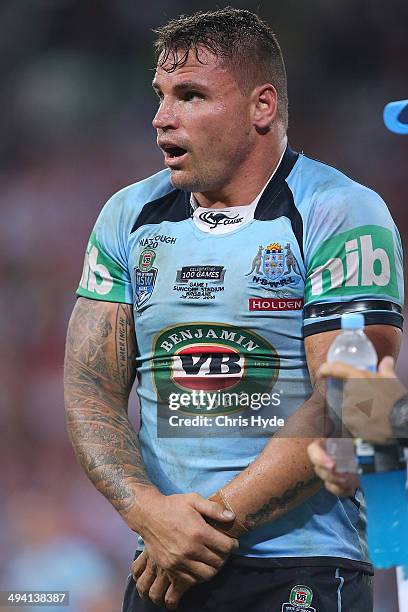 Anthony Watmough of the Blues holds his arm during game one of the State of Origin series between the Queensland Maroons and the New South Wales...