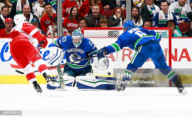 Gustav Nyquist of the Detroit Red Wings scores in overtime on Ryan Miller of the Vancouver Canucks as Yannick Weber of the Canucks reaches to stop...