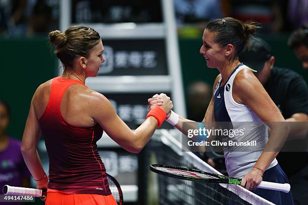 Simona Halep of Romania shakes hands with Flavia Pennetta of Italy after defeating her in a round robin match during the BNP Paribas WTA Finals at...