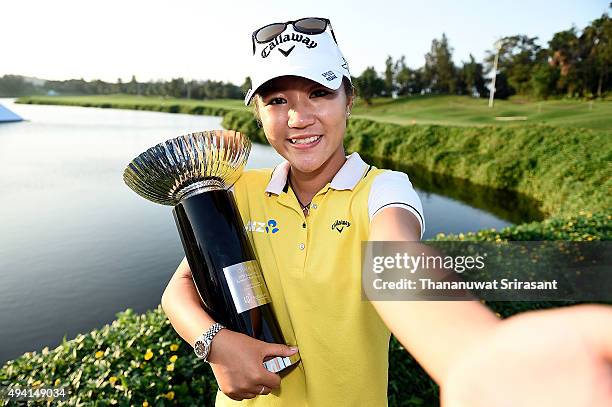 Lydia Ko pretends to take a selfie while holding the trophy on the 18th green after winning 2015 Fubon LPGA Taiwan Championship on October 25, 2015...