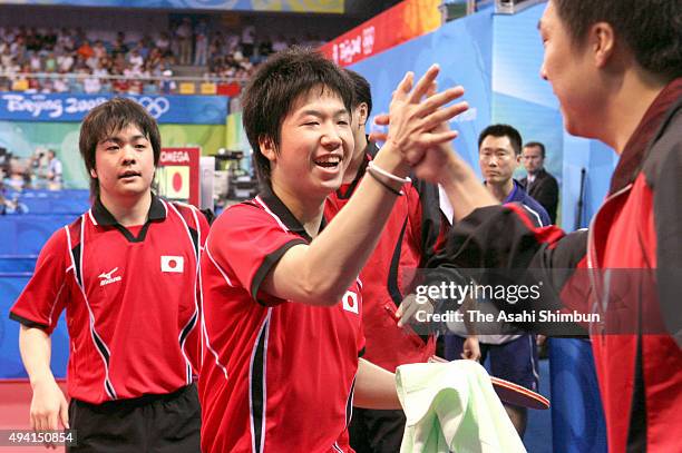 Jun Mizutani and Seiya Kishikawa of Japan celebrate their doubles win with Yo Kan in the men's team table tennis against Hong Kong at the Peking...