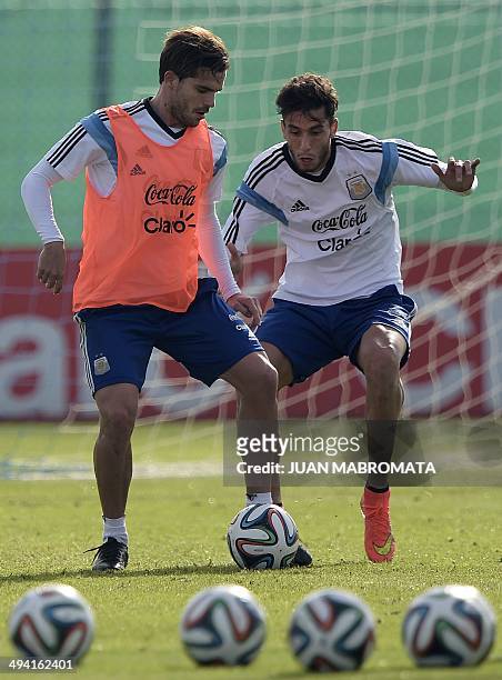 Argentina's midfielders Fernando Gago and Ricky Alvarez vie during a training session at the squad's training complex in Ezeiza, in the province of...