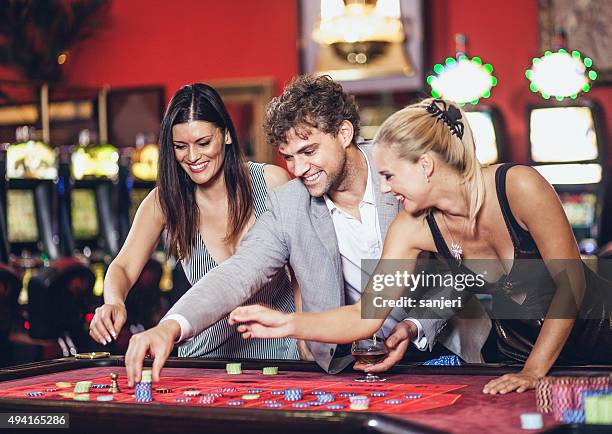 young people playing roulette at the casino - roulette stock pictures, royalty-free photos & images