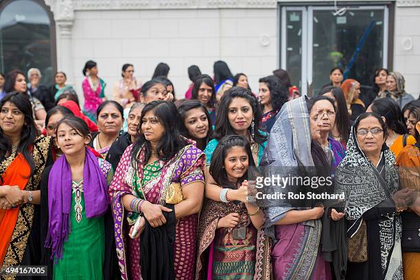 Women watch the Shree Muktajeevan Pipe Band greet the Mayor of London Boris Johnson upon arrival at the Shree Swaminarayan Mandir, a major new Hindu...