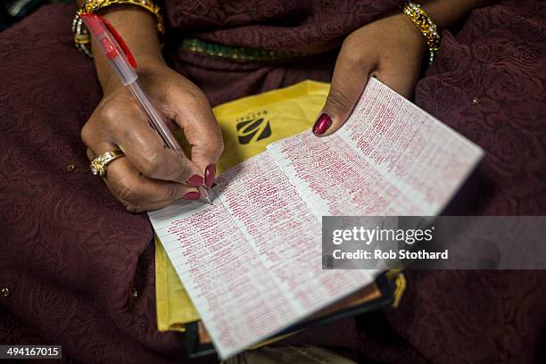 Woman writes the name of god Swaminarayanbapa Swamibapa at the Shree Swaminarayan Mandir, a major new Hindu temple being built in Kingsbury, before a...