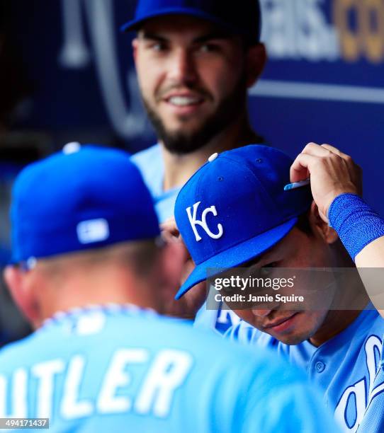 Norichika Aoki of the Kansas City Royals adjusts his sunglasses in the dugout alongside Eric Hosmer and Billy Butler prior to the start of the game...