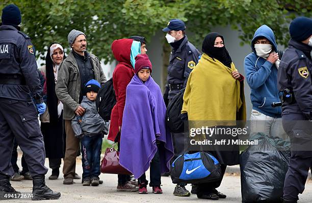 Migrants leave Brezice refugee camp to board buses as they continue they journey north towards Austria on October 25, 2015 in Brezice, Slovenia....