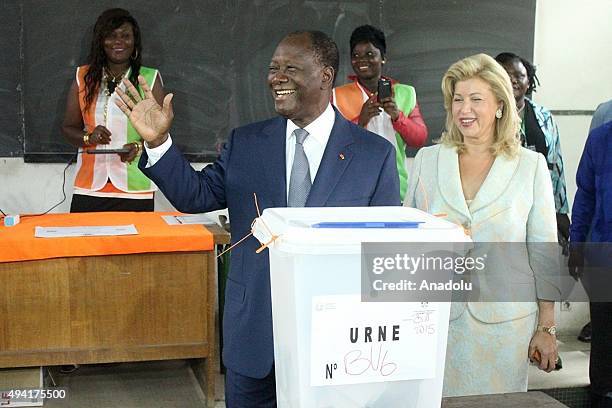 President of Ivory Coast Alassane Ouattara and his wife Dominique Folloroux-Ouattara pose after casting their votes in Saint Mary High School during...