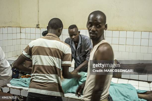 Relatives look on as two bodies are prepared in the morgue of the General Hospital in Bangui on May 28, 2014 after ten people were killed and several...