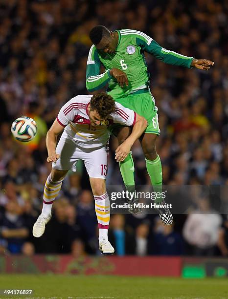 Azubuike Egwuekwe of Nigeria is challenged by Chris Martin of Scotland during an International Friendly between Scotland and Nigeria at Craven...