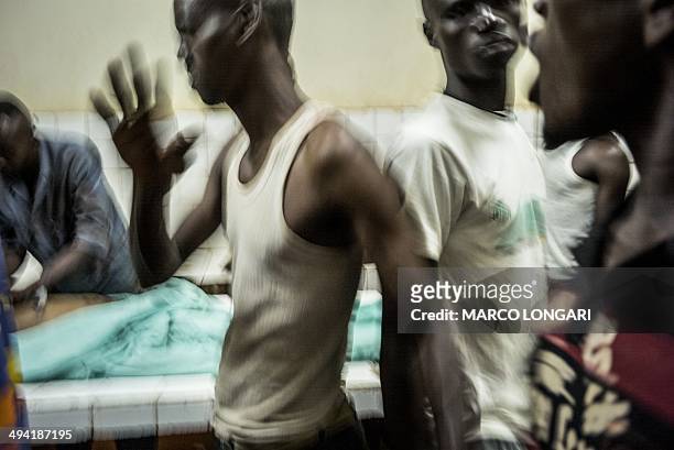 Relatives react as two bodies are prepared in the morgue of the General Hospital in Bangui on May 28, 2014 after ten people were killed and several...
