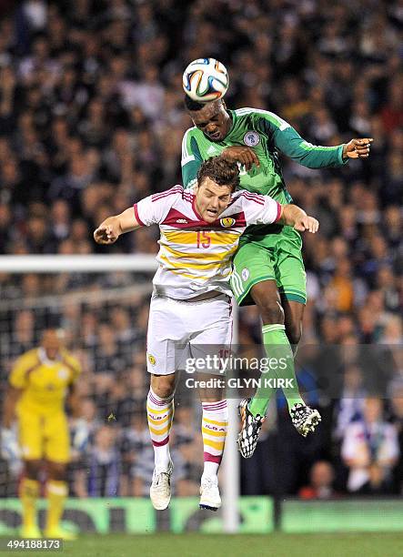 Nigeria's defender Azubuike Egwuekwe jumps for the ball with Scotland's striker Chris Martin during the international friendly football match between...