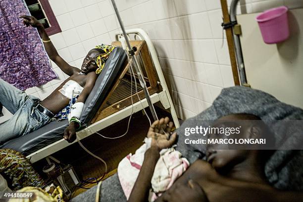 Wounded patients receive medical care in the ward of the "Hopital Communautaire" in Bangui on May 28, 2014. At least 10 people were killed and...