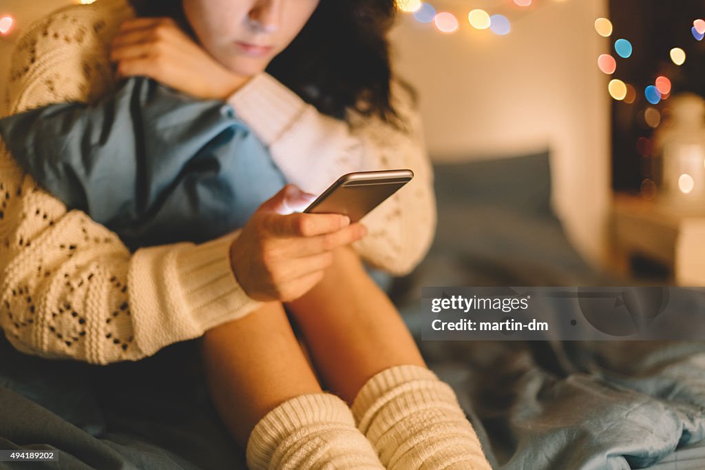 Mädchen im Bett mit Telefon