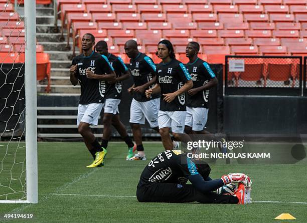 Honduras national team goalkeeper Noel Valladares stretches as teammates jog past during a training session in Washington on May 28, 2014 on the eve...