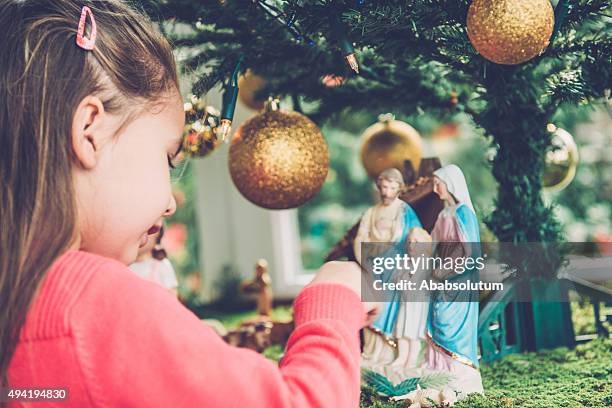 ragazza di quattro giocando con statuette di natività, europa - natività foto e immagini stock