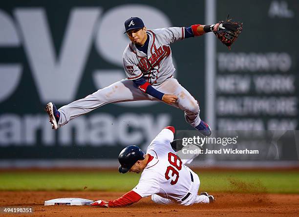 Ramiro Pena of the Atlanta Braves turns a double play over Grady Sizemore of the Boston Red Sox during the game at Fenway Park on May 28, 2014 in...