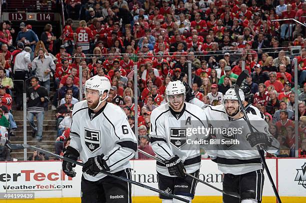 Anze Kopitar and Drew Doughty of the Los Angeles Kings celebrate behind teammate Jake Muzzin, after the Kings scored against the Chicago Blackhawks...