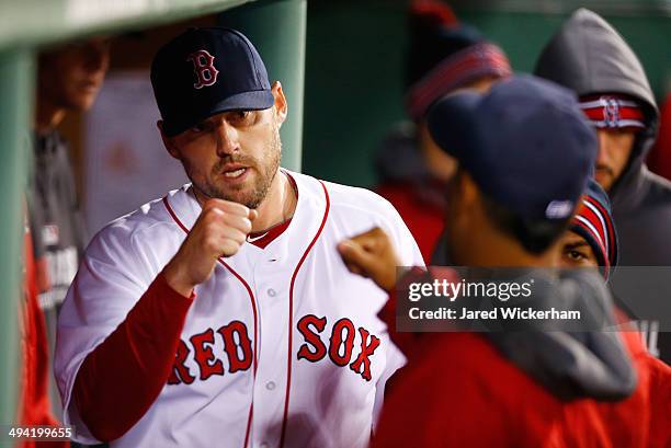 John Lackey of the Boston Red Sox is congratulated by teammates in the dugout after being pulled from the game in the 7th inning by manager John...