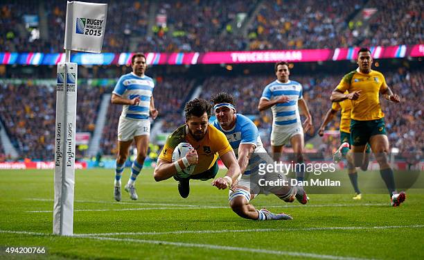 Adam Ashley-Cooper of Australia dives over to scores his sides second try despite the tackle by Pablo Matera of Argentina during the 2015 Rugby World...