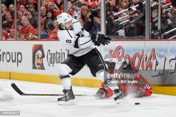 Drew Doughty of the Los Angeles Kings swings at the puck as Brandon Saad of the Chicago Blackhawks lays on the ice in Game Five of the Western...