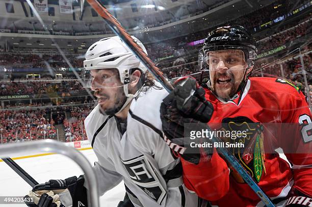 Drew Doughty of the Los Angeles Kings and Kris Versteeg of the Chicago Blackhawks skate around the boards in Game Five of the Western Conference...