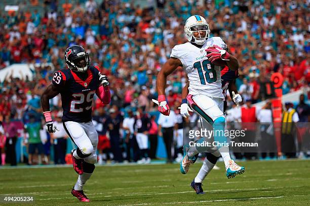 Rishard Matthews of the Miami Dolphins runs the ball back for a touchdown in the first quarter as Andre Hal of the Houston Texans looks on during a...