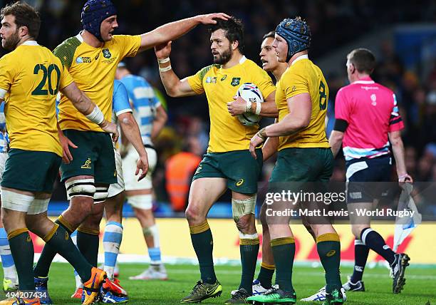 Adam Ashley-Cooper of Australia is congratulated by team mates on scoring their fourth try and his hat trick during the 2015 Rugby World Cup Semi...