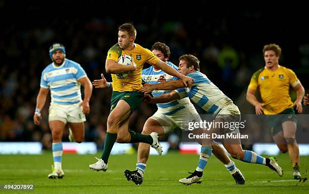 Drew Mitchell of Australia breaks the challenge of Julian Montoya and Santiago Cordero of Argentina on the way to setting up Adam Ashley-Cooper to...