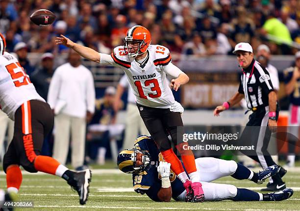 Josh McCown of the Cleveland Browns throws the ball while avoiding the sack by Aaron Donald of the St. Louis Rams in the first quarter at the Edward...