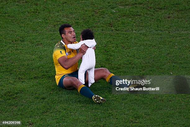 Will Genia of Australia sits on the field with his daughter Olivia during the 2015 Rugby World Cup Semi Final match between Argentina and Australia...