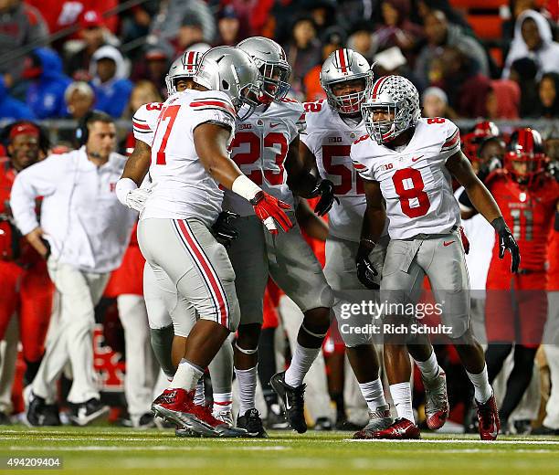 Gareon Conley of the Ohio State Buckeyes is congratulated by teammates Michael Hill, Tyvis Powell and Donovan Munger after intercepting a pass...