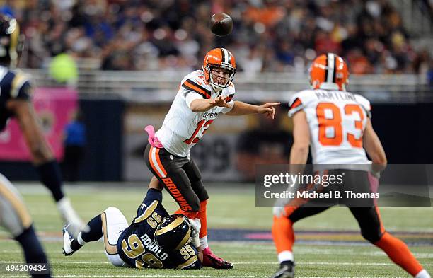 Josh McCown of the Cleveland Browns throws a pass to Brian Hartline as he avoids beinf sacked by Aaron Donald of the St. Louis Rams in the first...