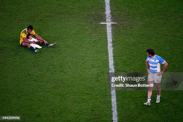 Marcelo Bosch of Argentina looks on as Will Genia of Australia sits on the field with his daughter Olivia during the 2015 Rugby World Cup Semi Final...