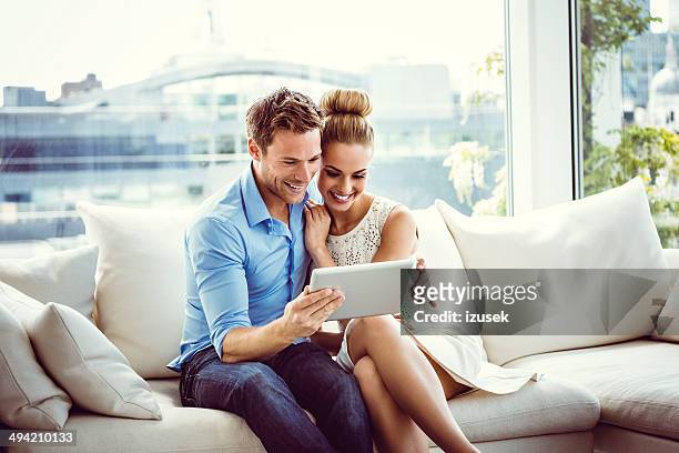 couple using a digital tablet - elegant couple stockfoto's en -beelden