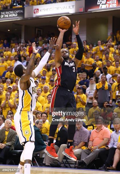 Dwyane Wade of the Miami Heat takes a shot over Paul George of the Indiana Pacers during Game Five of the Eastern Conference Finals of the 2014 NBA...