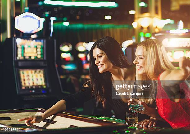 young people playing roulette at the casino - roulotte stock pictures, royalty-free photos & images