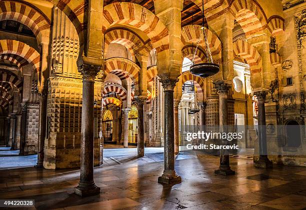 moorish style arches within the mezuita in cordoba, spain - córdoba spanje stockfoto's en -beelden