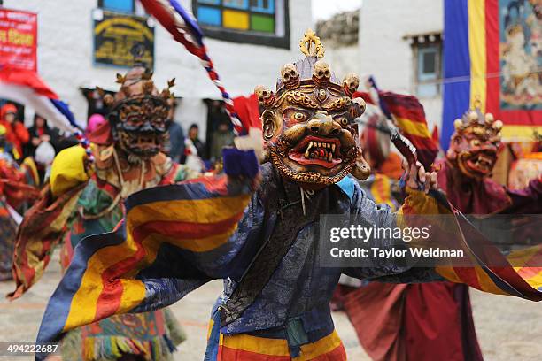 Elaborately dressed monks costumed as wrathful guardian spirits perform ceremonial dances during the Tenchi Festival on May 25, 2014 in Lo Manthang,...