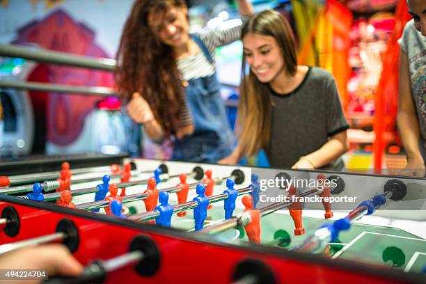 friends playing foosball at the arcade game - arcade game stock pictures, royalty-free photos & images